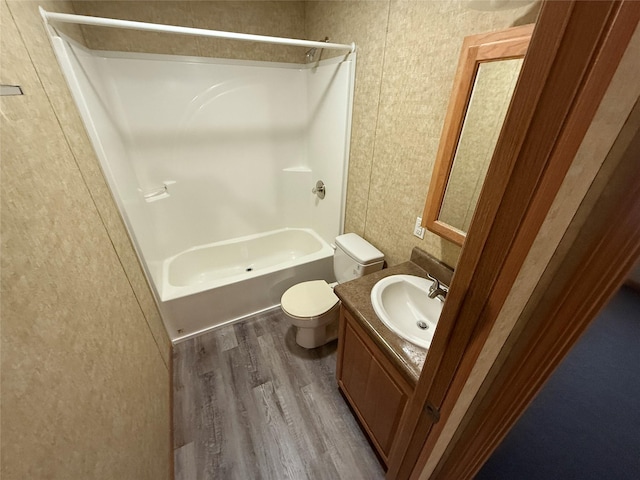 full bathroom with bathing tub / shower combination, toilet, vanity, and hardwood / wood-style flooring