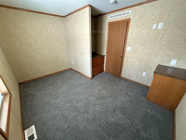 unfurnished bedroom with dark carpet and crown molding