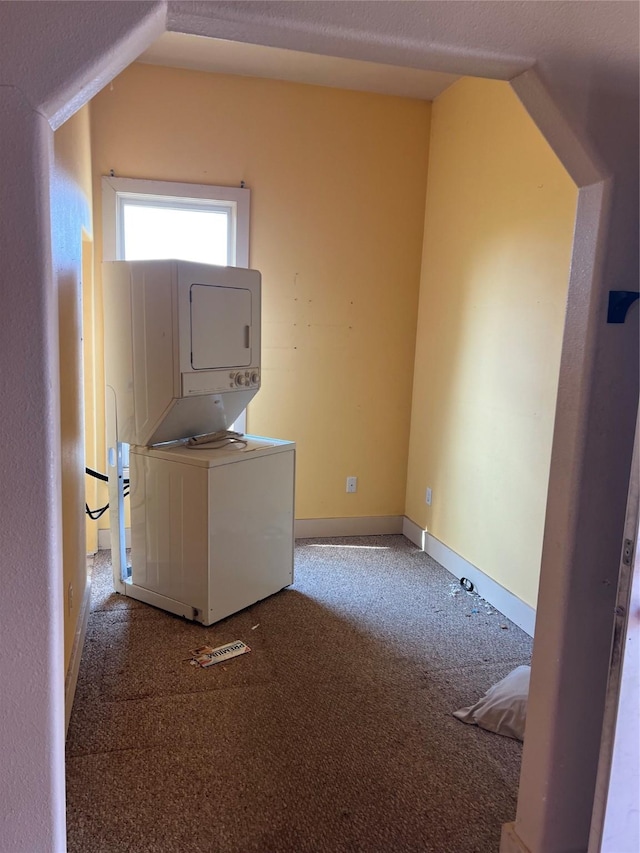 washroom featuring stacked washer / dryer and carpet floors