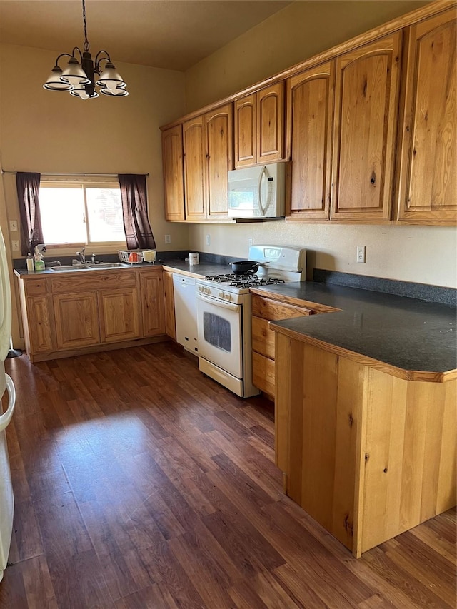 kitchen featuring an inviting chandelier, dark hardwood / wood-style flooring, kitchen peninsula, pendant lighting, and white appliances