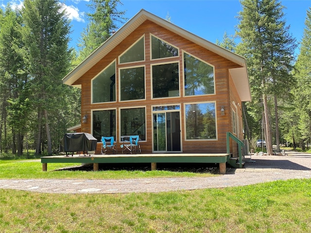 rear view of house with a lawn and a deck