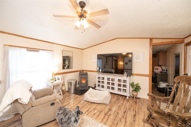 living room with a wood stove, ceiling fan, wood-type flooring, a textured ceiling, and lofted ceiling