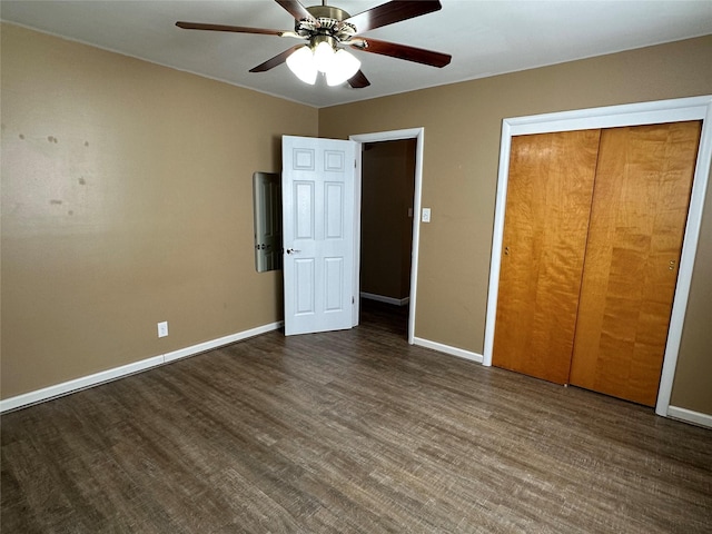 unfurnished bedroom featuring ceiling fan, dark wood-type flooring, and a closet