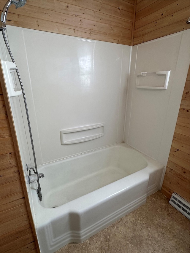 bathroom with bathtub / shower combination and wooden walls