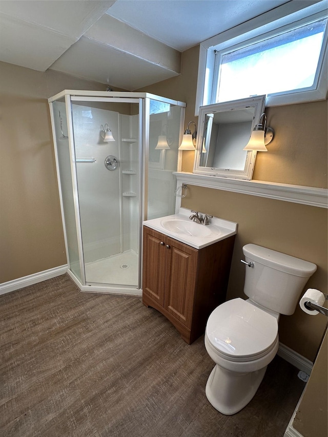 bathroom featuring a shower with door, vanity, and toilet