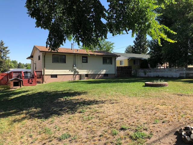 rear view of property featuring cooling unit and a yard