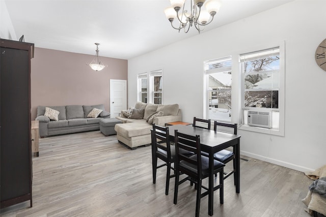 dining room with light hardwood / wood-style floors, an inviting chandelier, and cooling unit