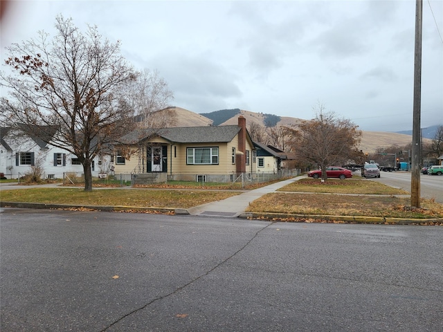 view of front of home with a mountain view and a front lawn