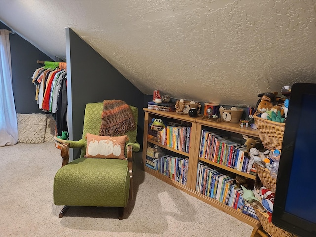 sitting room featuring carpet, a textured ceiling, and lofted ceiling