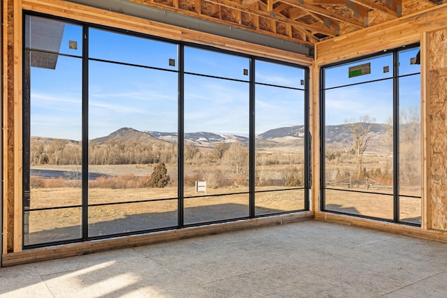 unfurnished sunroom featuring a mountain view and a rural view