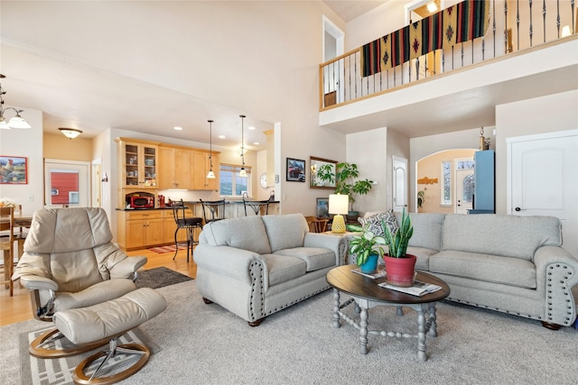 living room featuring light wood-type flooring and a high ceiling