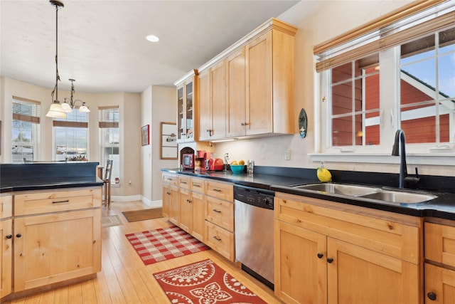 kitchen featuring light wood-type flooring, stainless steel dishwasher, sink, pendant lighting, and light brown cabinets