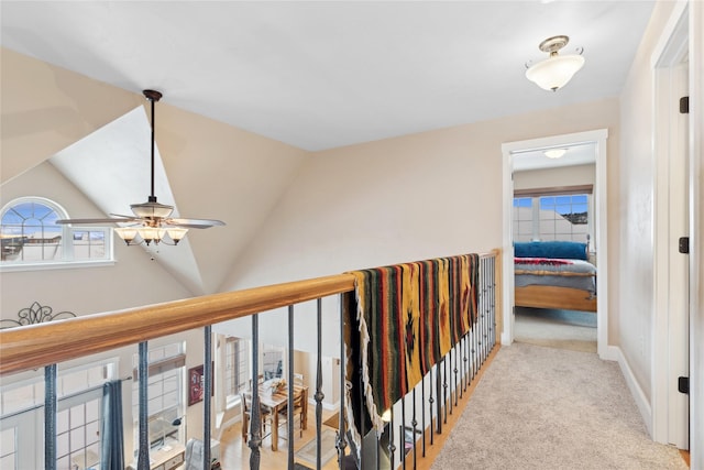 hall featuring light colored carpet and lofted ceiling