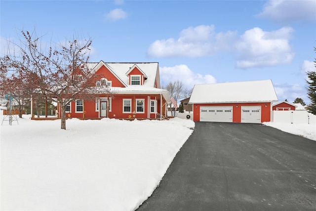 new england style home featuring a garage and an outdoor structure