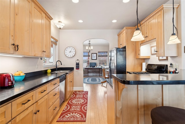 kitchen with sink, light hardwood / wood-style flooring, decorative light fixtures, a breakfast bar, and appliances with stainless steel finishes