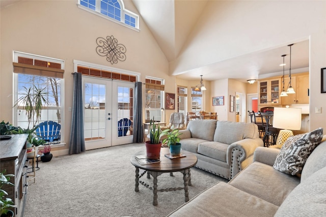 living room with light carpet, french doors, and a high ceiling