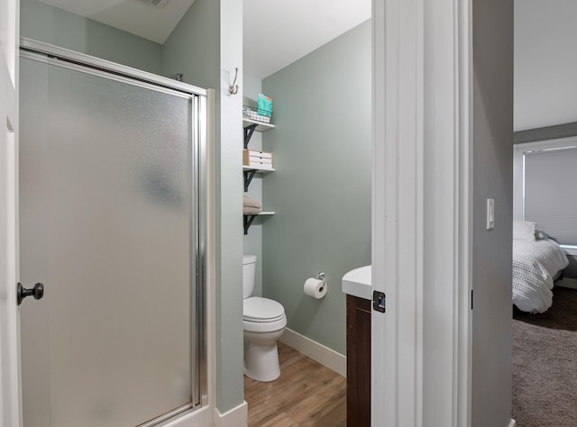 bathroom with hardwood / wood-style floors, toilet, and walk in shower