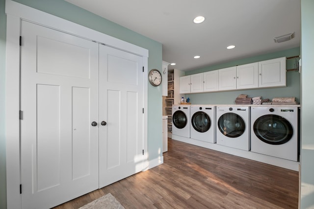 laundry area featuring cabinets, separate washer and dryer, and dark hardwood / wood-style floors