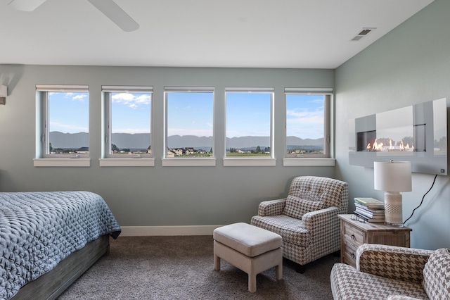 bedroom with carpet, ceiling fan, and a mountain view