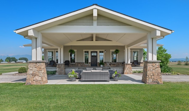 back of house with a lawn and outdoor lounge area