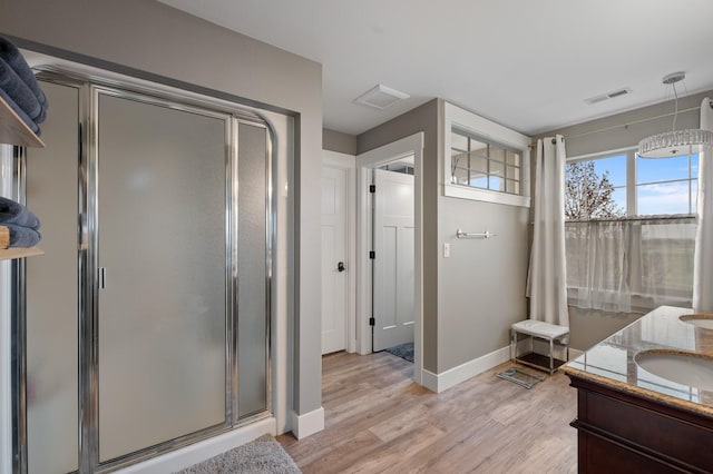 bathroom featuring vanity, a shower with shower door, and hardwood / wood-style flooring