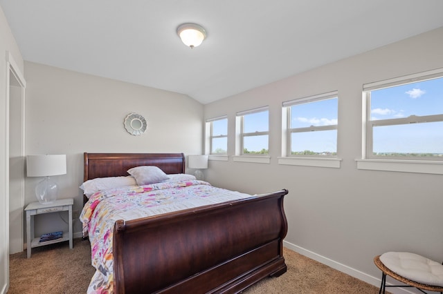 carpeted bedroom with lofted ceiling