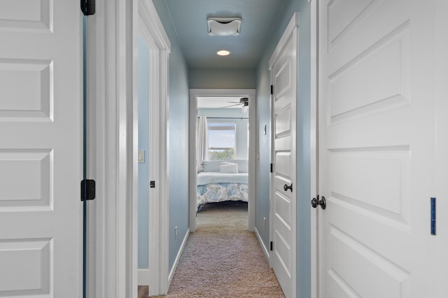 hall with light colored carpet