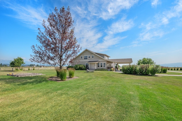 view of front facade with a rural view and a front lawn