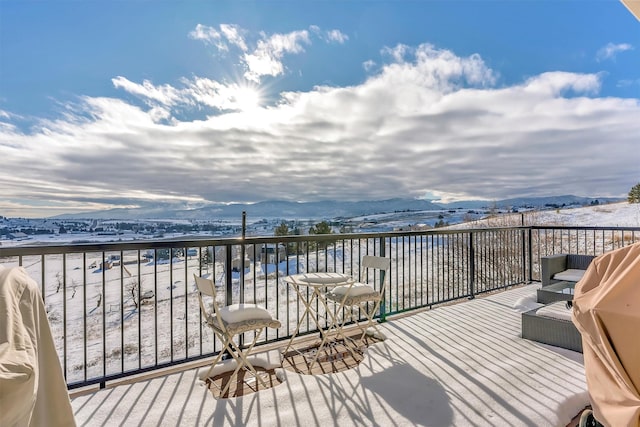 snow covered deck featuring area for grilling and a mountain view