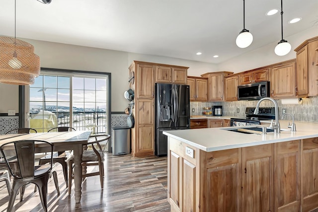 kitchen featuring a water view, wood-type flooring, hanging light fixtures, and appliances with stainless steel finishes