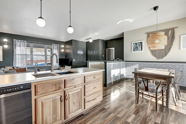 kitchen featuring dishwasher, light brown cabinets, sink, and decorative light fixtures