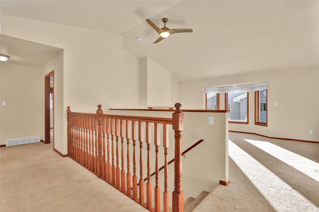 empty room featuring light carpet, ceiling fan with notable chandelier, plenty of natural light, and lofted ceiling