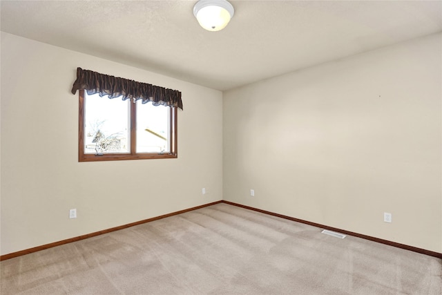 unfurnished room featuring light carpet