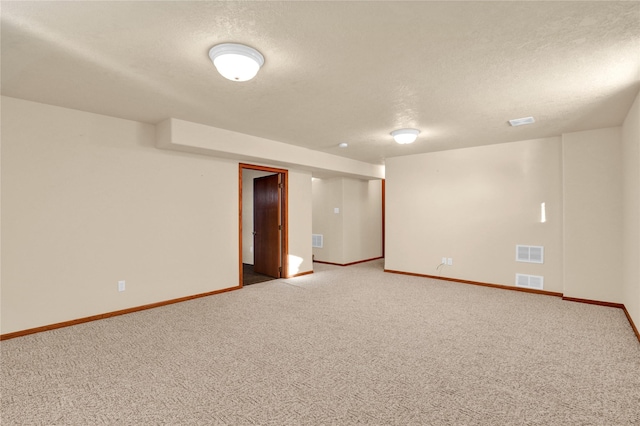 unfurnished room featuring carpet and a textured ceiling