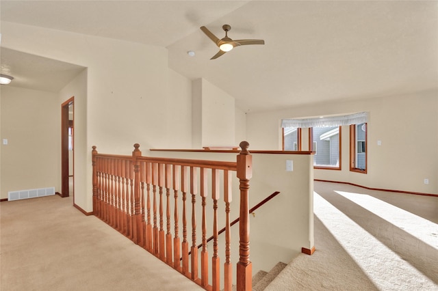 hall with lofted ceiling and light carpet