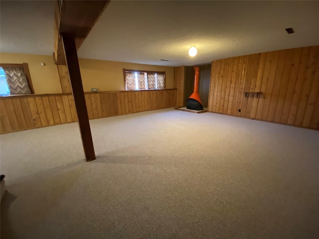 basement with wooden walls, a textured ceiling, and carpet