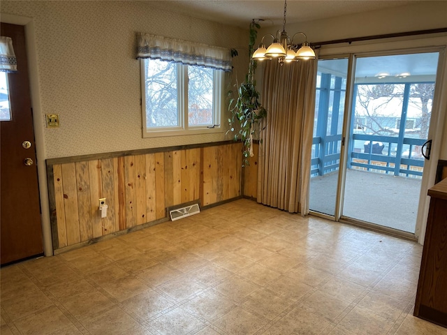 unfurnished dining area featuring a chandelier