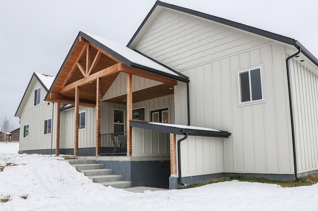 view of snowy exterior featuring a porch