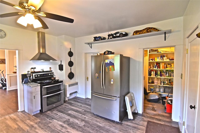 kitchen featuring dark hardwood / wood-style flooring, radiator, wall chimney range hood, and appliances with stainless steel finishes