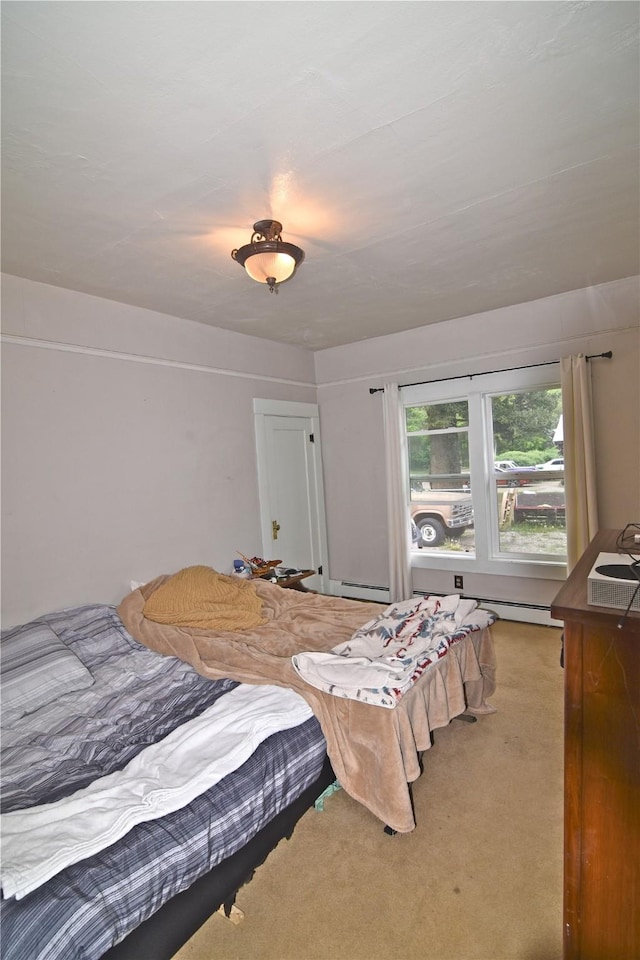 bedroom with carpet flooring and a baseboard heating unit