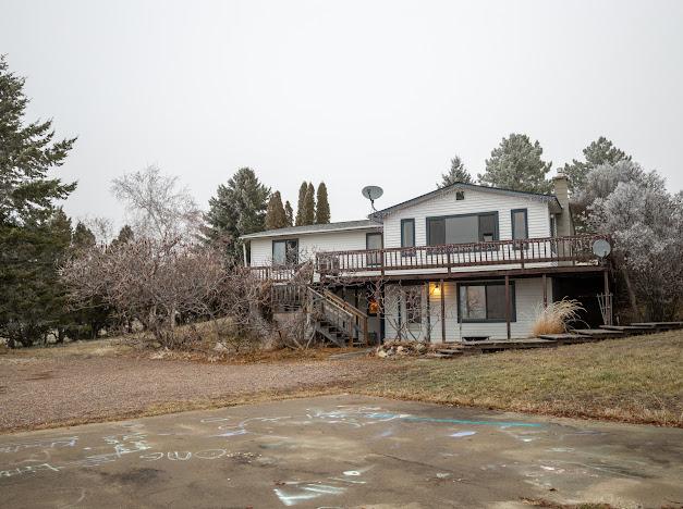 view of front of house with a deck and a front yard