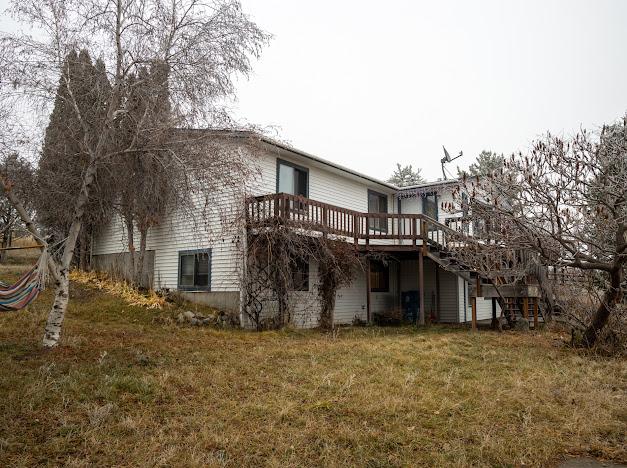 rear view of house featuring a deck and a yard