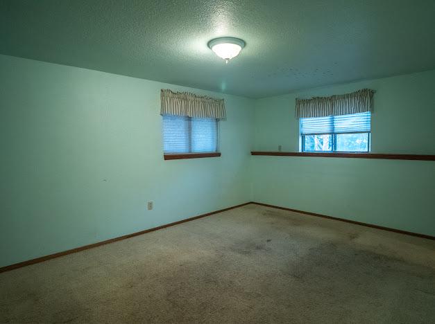 carpeted spare room with a textured ceiling