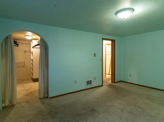 carpeted empty room with a textured ceiling