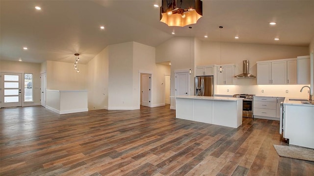 kitchen featuring appliances with stainless steel finishes, a kitchen island, pendant lighting, and wall chimney range hood