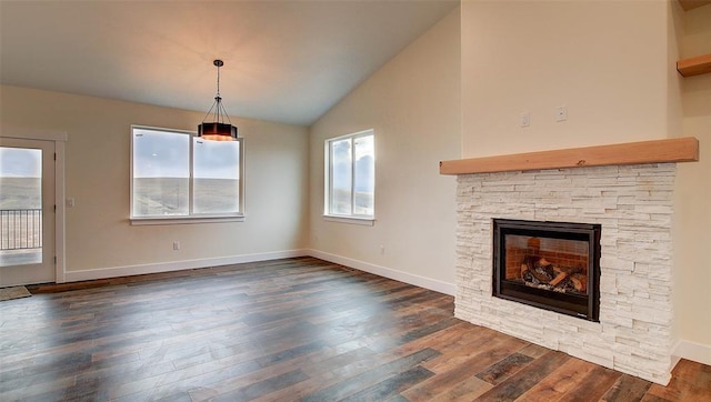 unfurnished living room with plenty of natural light, dark hardwood / wood-style floors, lofted ceiling, and a fireplace