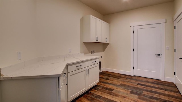 clothes washing area featuring electric dryer hookup, cabinets, dark hardwood / wood-style floors, and washer hookup