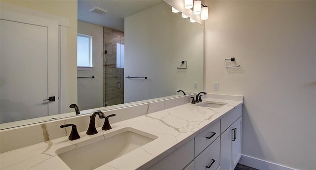 bathroom featuring a shower with door and vanity