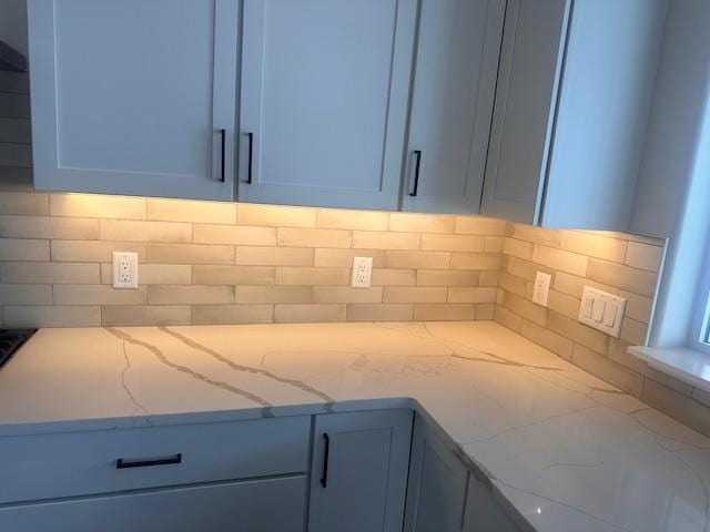 kitchen featuring light stone counters and backsplash