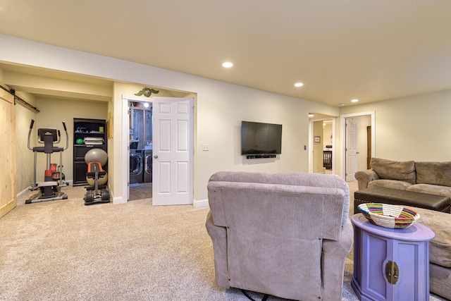 living room featuring carpet, a barn door, and washing machine and clothes dryer